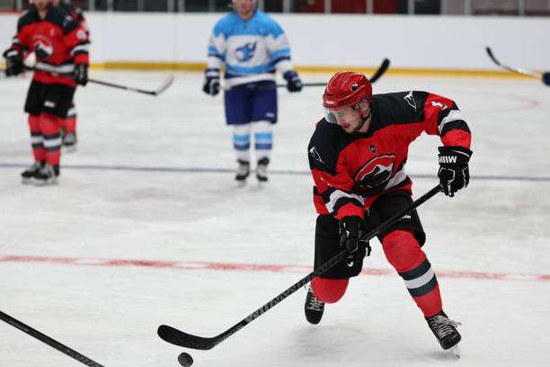 istock Red Team Player Controlling the Puck on the Ice 2185357908
