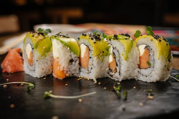 istock Sushi rolls with avocado and salmon garnished with microgreens. 2185359230