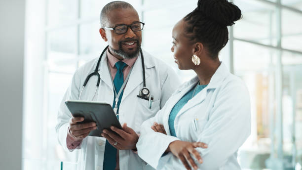 istock Teamwork, internet and doctors with tablet, healthcare and feedback for schedule. Employees, medical or professional in hospital, tech or research with mentor, advice or digital app with conversation 2185361132