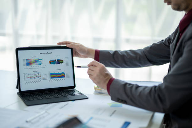 istock A man is pointing at a laptop screen with a graph on it 2185362731