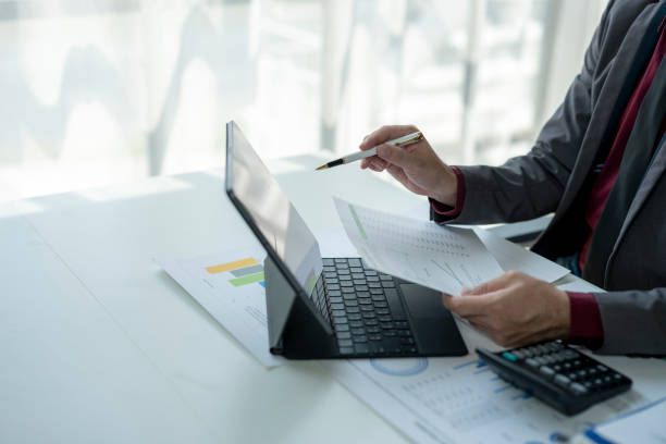 istock A man is sitting at a desk with a laptop and a pen 2185363375