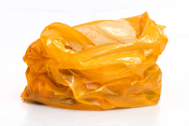 Bio organic trash sorted in yellow plastic bag for composting or recycling isolated on white background.