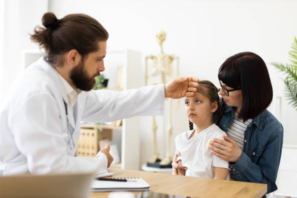istock Doctor checking temperature of sick child with concerned mother 2185366853