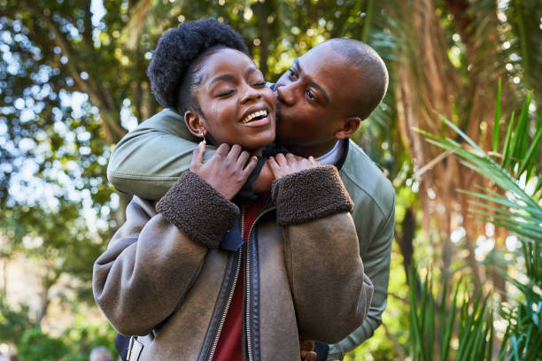 istock Happy Couple Embracing in the Park with Lush Greenery and Sunlight 2185368306