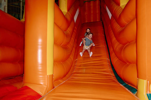 istock Excited friends moving down steep slide 2185368412