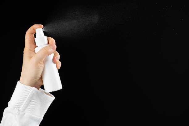 istock Spray in hand, black background. Spraying the product from a plastic bottle 2185368643