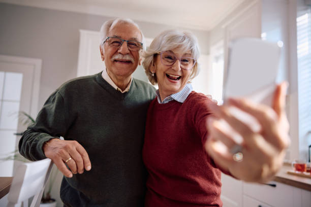 istock Cheerful senior couple taking selfie with cell phone at home. 2185369065