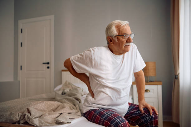 istock elderly man feeling pain in his lower back in the morning. 2185369148