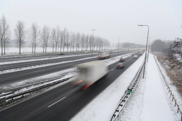 istock Moving traffic on a highway during a snow blizzard in winter 2185370112