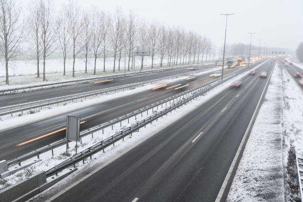 istock Moving traffic on a highway during a snow blizzard in winter 2185370199
