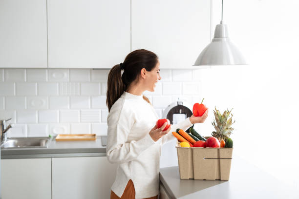 istock Woman preparing fresh vegetables in modern kitchen setting 2185373750
