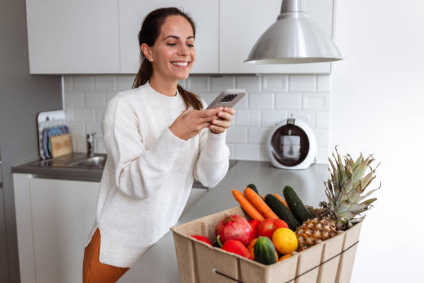 istock Woman photographing fresh produce in modern kitchen setting 2185373794