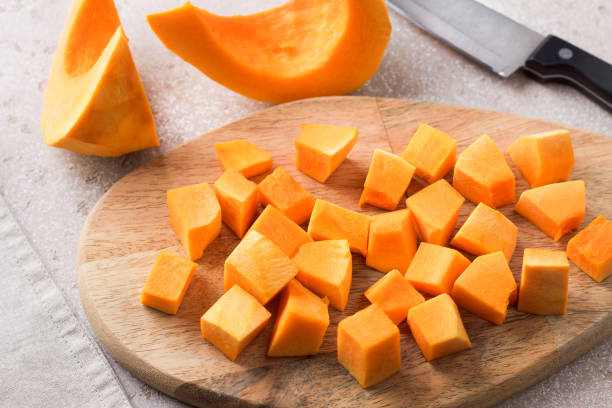 istock Pumpkin cut into pieces on a wooden board on a beige textured background 2185374746