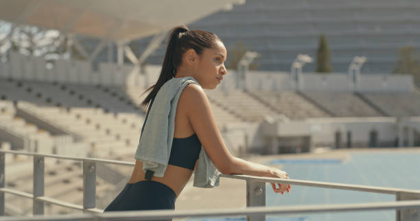 istock A female athlete taking a break after exercise at a stadium and thinking. Young woman looking thoughtful after playing sport outdoors 2185376384