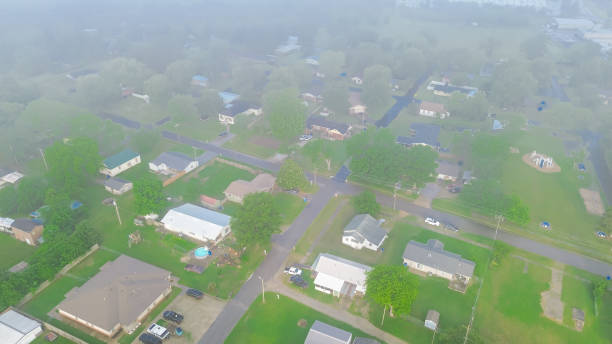 Panorama aerial view misty landscape of Midwest small town USA in Checotah, McIntosh County, Oklahoma, residential country houses on large acre land agro-town lush green trees foggy morning. USA vista aérea panorámica paisaje brumoso de la pequeña ciudad del medio oeste de ee. uu. en checotah, condado de mcintosh, oklahoma, casas de campo residenciales en la tierra de gran acre agro-town exuberantes árboles verdes brumosos mañana