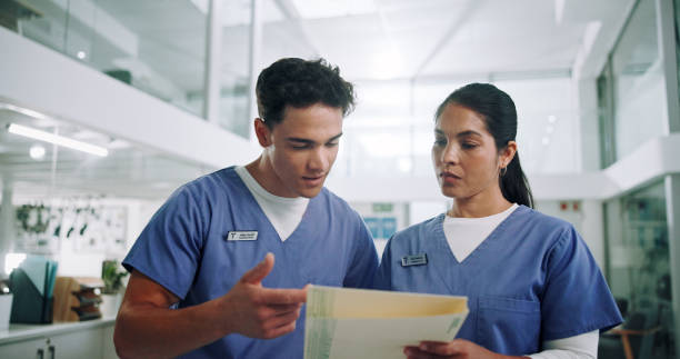 istock Team, nurse and folder with discussion for medical history, patient results or application at hospital. Man, woman or healthcare workers with documents or paperwork for health procedure at clinic 2185377935