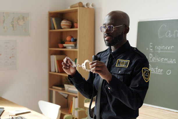 istock Policeman in uniform holding handcuffs 2185379178