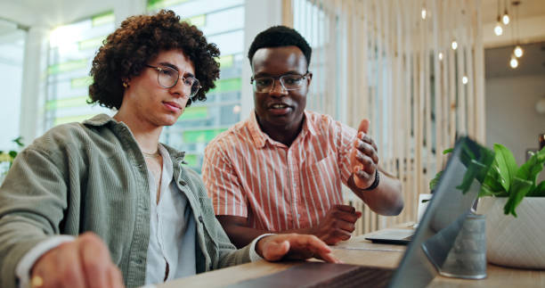 istock Business men, laptop and team training, help and feedback for project review in creative startup office. Computer, collaboration or coaching with mentor for internship, advice or learning copywriting 2185379435