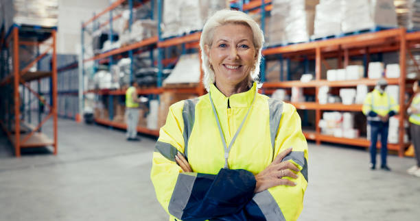 istock Logistics, happy woman or portrait in warehouse with confidence, coordination or distribution. Mature manager, arms crossed or pride in storage facility with team, export and shipping in supply chain 2185379612