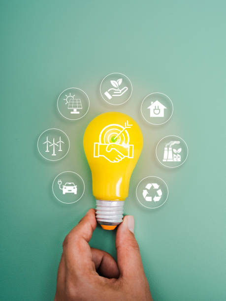 istock Reduce CO2 emissions sustainable, carbon dioxide reduction, limit climate change concept. Cooperation icon on yellow lightbulb in hand, surrounded with renewable icons isolated on green background. 2185379713