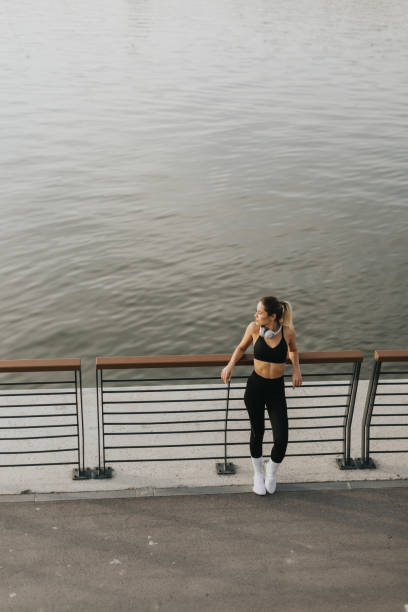 istock A confident athlete enjoys a moment of reflection while stretching on a riverfront path during golden hour 2185379913