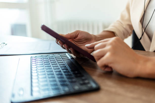istock Young woman using mobile phone and working at home office with headphones on. 2185381114
