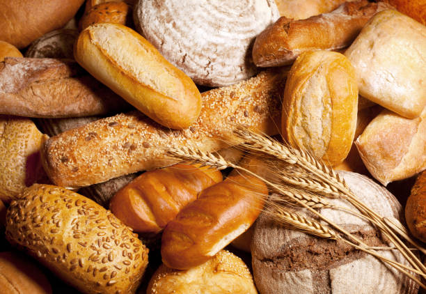 fresh fragrant bread on the table - padaria imagens e fotografias de stock