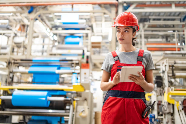 istock Industrial engineer analyzing data on tablet surrounded by large machinery in factory setting. 2185383895