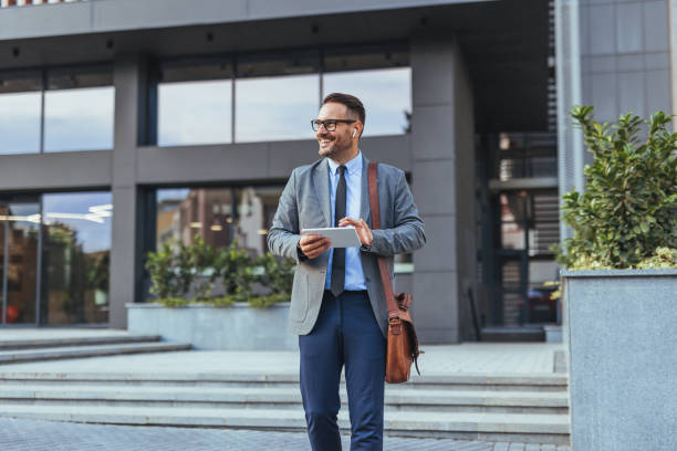 istock Confident Businessman Walking Outdoors With Digital Tablet 2185383972