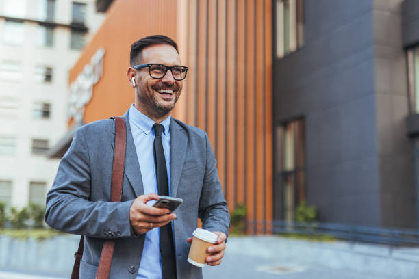 Businessman Walking Outside with Coffee and Smartphone