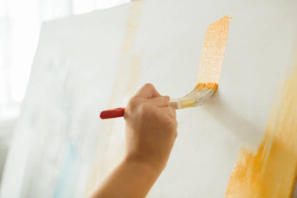 Close-up of a female painter working with brushes and paints