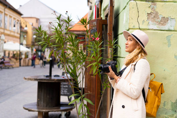 istock Stylish traveler using smartphone next to vibrant street backdrop with historic architecture. 2185386380
