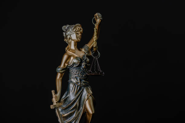 istock Lady Justice Statue Against Black Background 2185387010