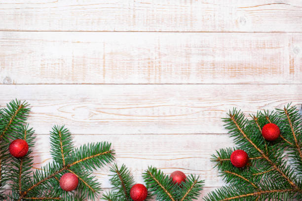 istock Christmas background - fir branches and red ornaments on a white wood table. Flat layout, top view composition border with copy space 2185387252