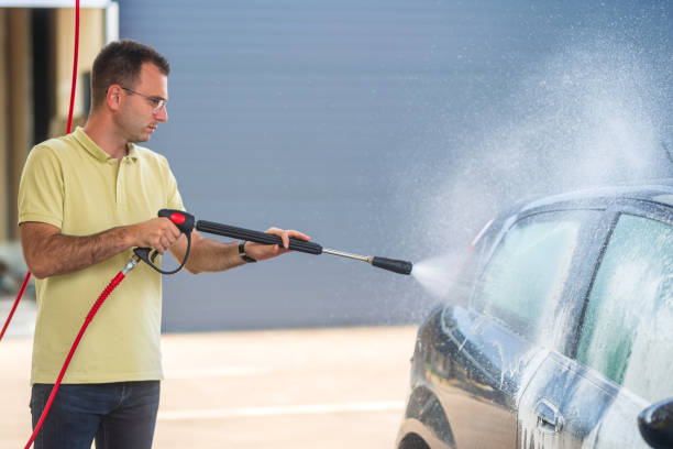istock Man washing car with pressure washer: cleaning service using high pressure water jet 2185389176