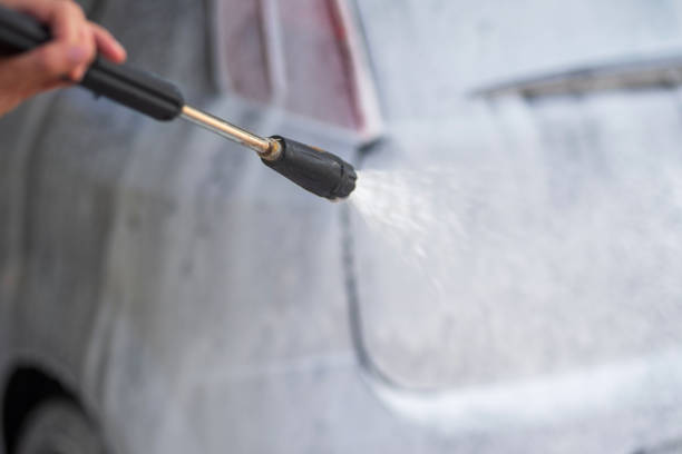 istock Car wash worker cleaning vehicle with high pressure washer 2185389436