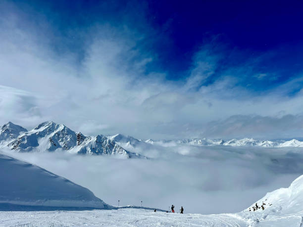 over the fog in the mountains in the winter with snow and blue sky