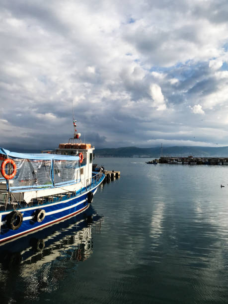 istock Serene harbor view with a boat under cloudy sky. Nessebar, Bulgaria 2185393081