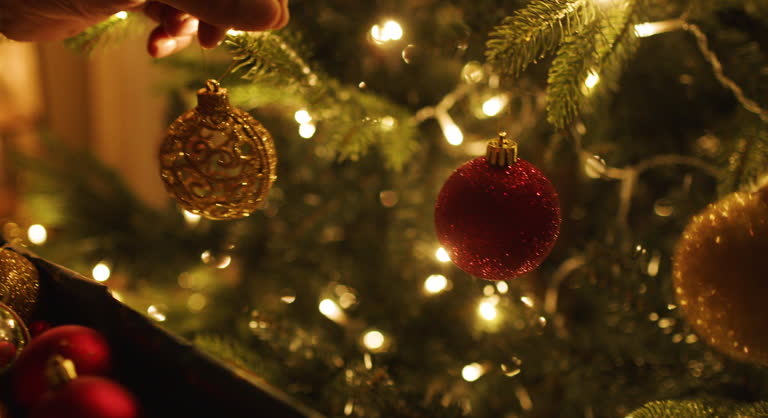 Close-up of a man's hands decorating Christmas tree