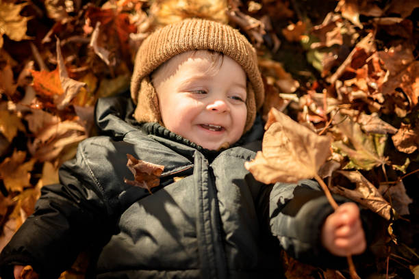 istock baby boy having fun on Autumn Forest 2185396602