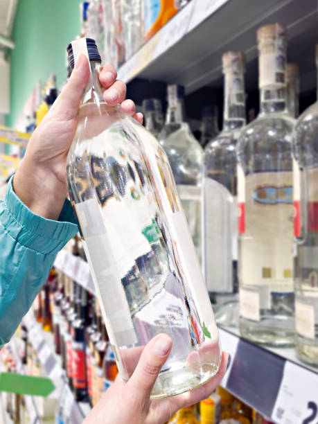 istock Bottle of vodka in hands in store 2185397435