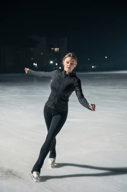 istock Beautiful young woman ice skating and performing short program 2185398031