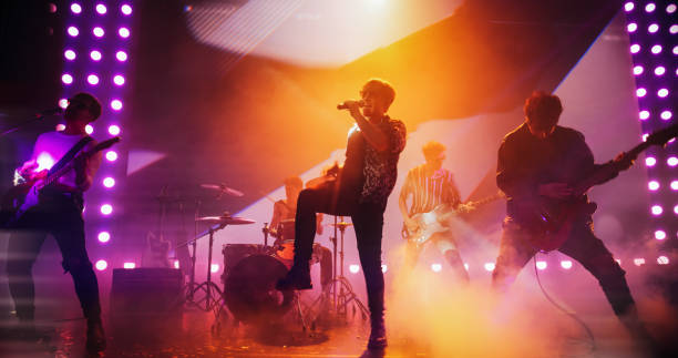 istock Energetic Rock Band Performing on a Nightclub Stage with Dynamic Lights, Animated LED Screen and Special Effects. Rock Music Artists Creating a Unique Show Experience With Powerful Alternative Music 2185398470