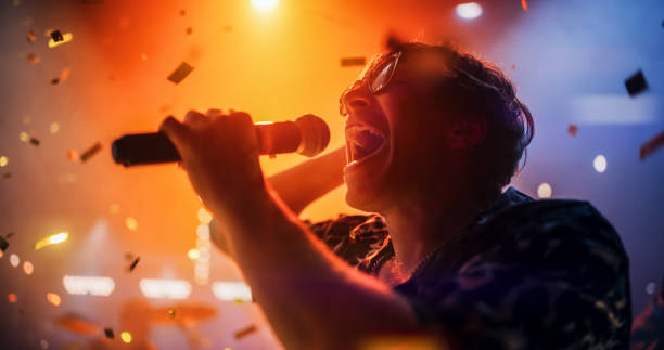 istock Energetic Rock Band Performing on a Nightclub Stage with Dynamic Lights and Special Effects. Portrait of an Artist Creating a Unique Show Experience With Powerful Alternative Songs 2185398720
