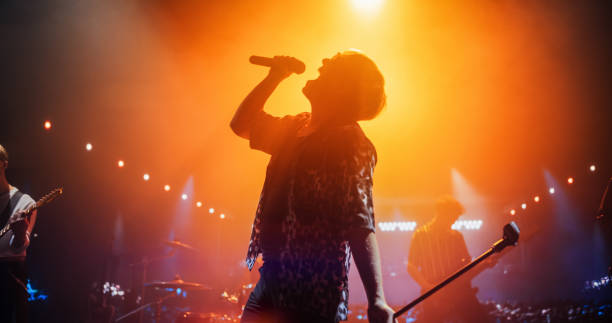 istock Energetic Rock Band Performing on a Nightclub Stage with Dynamic Lights and Special Effects. Portrait of an Artist Creating a Unique Show Experience With Powerful Alternative Songs 2185399456