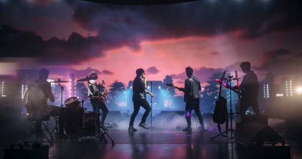 Indie Rock Band Delivers a Mesmerizing Live Performance With Guitars and Drums at a Massive Nightclub. Colorful Lights and Powerful Sound at a Rock Festival. Footage From the Back