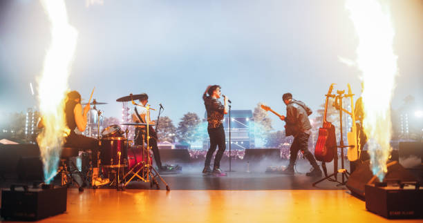 istock Energetic Rock Band Performing on Festival Stage with Fire Pyrotechnics Special Effects. Rock Music Artists Creating a Unique Show Experience With Dynamic Visuals and Powerful Alternative Music 2185400699