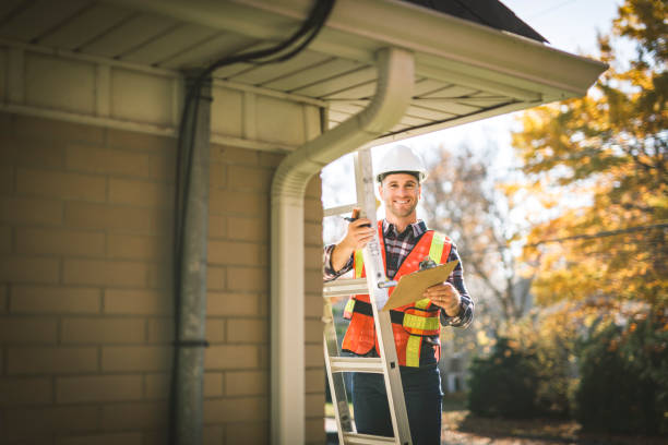 istock man with hard hat standing on steps inspecting house roof 2185401434