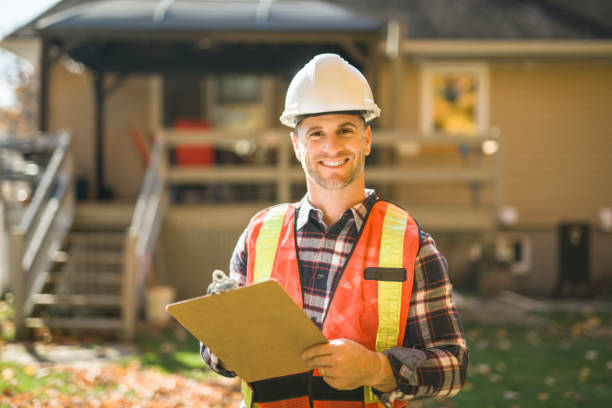 istock man with hard hat standing infront of a house 2185401491
