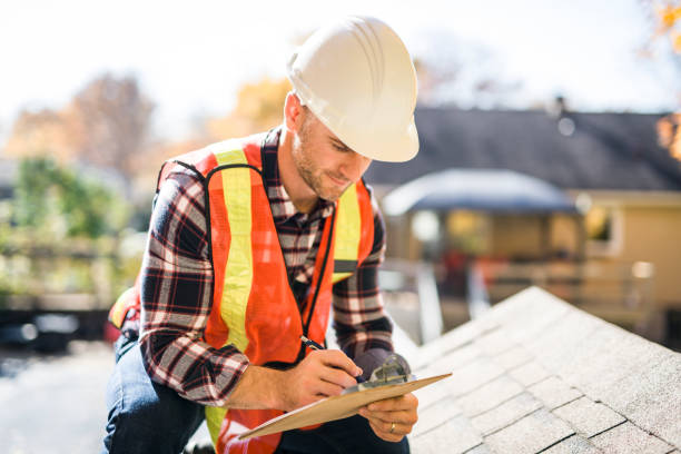 istock man with hard hat standing on steps inspecting house roof 2185402024